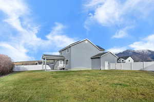 Rear view of property with a fenced backyard, stucco siding, a mountain view, and a patio
