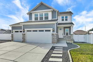 Craftsman inspired home featuring stone siding, driveway, a gate, and a shingled roof