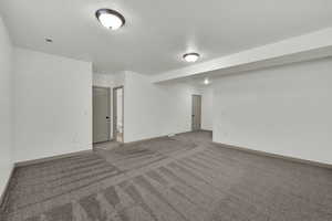 Carpeted spare room with baseboards and a textured ceiling
