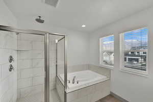 Bathroom with a stall shower, a bath, and a textured ceiling