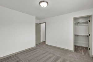 Unfurnished bedroom featuring a spacious closet and carpet