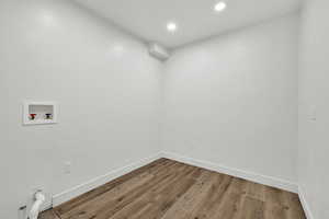 Laundry room with wood finished floors, hookup for a washing machine, and recessed lighting
