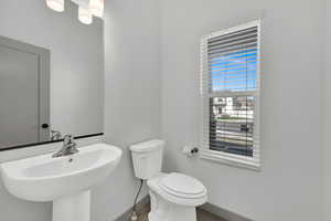 Half bath with toilet and baseboards
