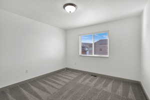 Spare room featuring carpet floors and a textured ceiling