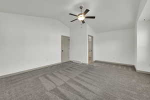 Unfurnished room with vaulted ceiling, carpet flooring, and a ceiling fan