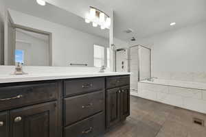 Bathroom featuring double vanity, a bath, a shower stall, and recessed lighting