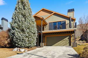 View of front of house with a balcony, concrete driveway, and a garage