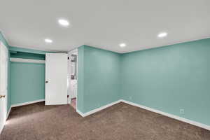 Basement featuring recessed lighting and dark colored carpet