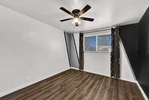 Spare room with dark wood-style floors and a ceiling fan