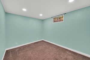 Spare room featuring dark carpet, recessed lighting, and crown molding