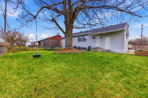 Rear view of house featuring a trampoline and brick siding