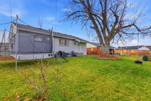 Rear view of property with a trampoline and brick siding