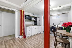 Basement featuring washer / dryer, freestanding refrigerator, light wood-style flooring, and a textured ceiling