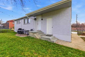 Rear view of property with brick siding, a trampoline, a yard, and entry steps