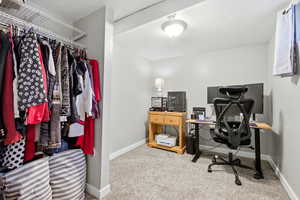 Office area featuring light carpet and baseboards