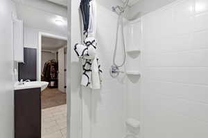 Full bathroom with vanity, a shower with curtain, and light tile patterned floors