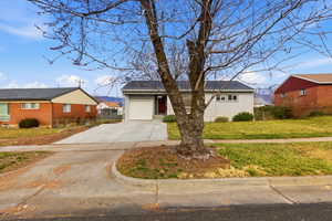 View of front of property with concrete driveway, brick siding, and a garage