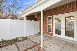 View of patio with french doors and a gate
