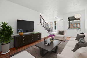 Living room with wood finished floors and a textured ceiling. Virtually Staged