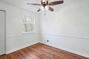bedroom 1 featuring wood finished floors, a ceiling fan, and a textured ceiling