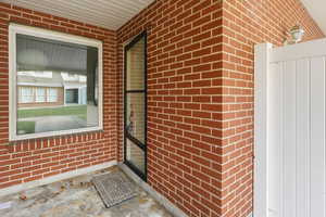 Property entrance featuring brick siding
