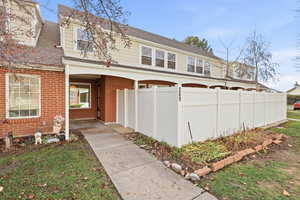 View of front of property featuring brick siding and roof with shingles
