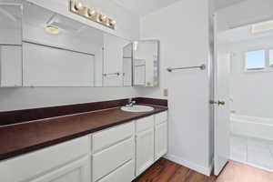 Bathroom with vanity, shower / bathtub combination, and dark wood-style floors