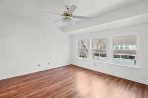 Primary bedroom featuring wood finished floors and a ceiling fan