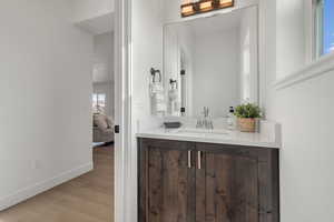 Powder Bathroom with vanity and light wood-style flooring