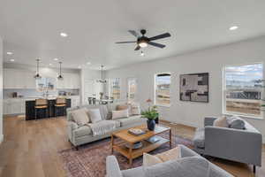 Living room with recessed lighting, light wood-type flooring, and a ceiling fan