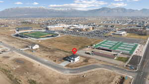 Aerial view of property and surrounding area featuring an industrial area and a mountainous background