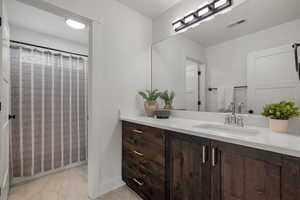 Main Full bathroom featuring vanity, curtained shower, and light marble finish flooring