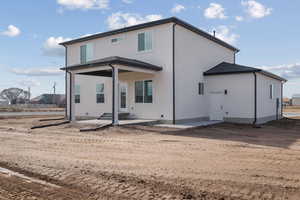Rear view of property featuring a patio area and stucco siding