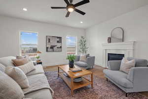 Living area featuring a fireplace, plenty of natural light, wood finished floors, ceiling fan, and recessed lighting
