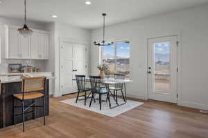 Dining area with a chandelier, light wood-style floors, and recessed lighting