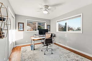 Home office with light wood finished floors and ceiling fan