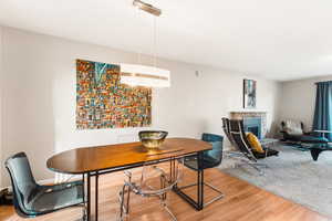 Dining area with a glass covered fireplace and light wood-style floors
