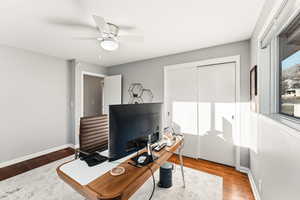 Office area with wood finished floors and ceiling fan