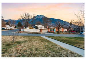 Yard at dusk featuring driveway and a mountain view
