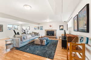 Living area featuring light wood-style flooring and a stone fireplace
