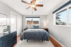 Bedroom with wood finished floors, a closet, and a ceiling fan