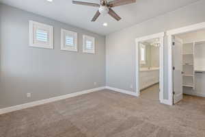 Unfurnished bedroom with a spacious closet, a chandelier, light carpet, ceiling fan, and recessed lighting