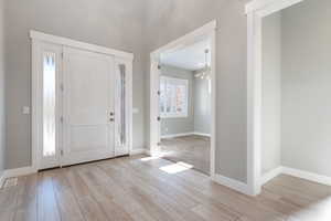 Entrance foyer featuring wood tiled floors and a chandelier