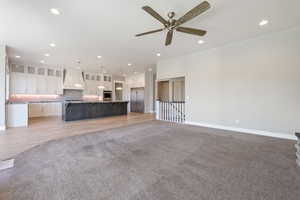 Unfurnished living room featuring recessed lighting, light colored carpet, ceiling fan, and light wood-style floors