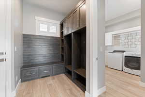 Mudroom featuring wood tiled floors and washer and dryer