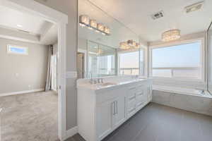 Bathroom with healthy amount of natural light, double vanity, a garden tub, and a shower stall