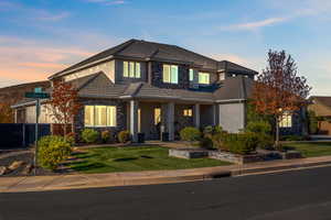 View of front of house with stone siding, stucco siding, a tiled roof, and a patio