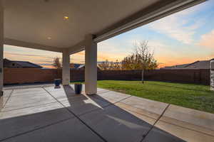 Patio terrace at dusk featuring a patio and a fenced backyard