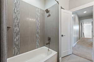 Bathroom featuring shower / tub combination, light carpet, light tile patterned floors, and recessed lighting