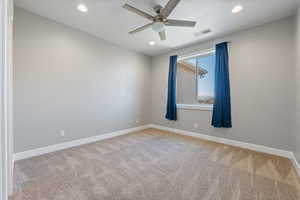 Spare room featuring light colored carpet, recessed lighting, and a ceiling fan